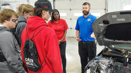 Students are shown what a car engine looks like during a collision shop tour at a recent Collision Career Pit Stop event.